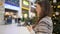 Young brunette woman checks social media in shopping mall