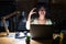 Young brunette woman with curly hair working at the office at night smiling and confident gesturing with hand doing small size