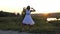 Young Brunette Woman Dances Disco Happily on a Lake Bank at Sunset in Slo-Mo