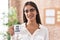 Young brunette woman drinking from i am the boss coffee cup looking positive and happy standing and smiling with a confident smile