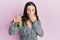 Young brunette woman drinking mojito glass covering mouth with hand, shocked and afraid for mistake