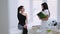 Young brunette woman in elegant wear sits in the cosmetologistâ€™s cabinet, the beautician examines her face, they