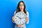 Young brunette woman holding big clock afraid and shocked with surprise and amazed expression, fear and excited face