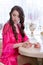 young brunette woman in kitchen wearing pink dressing gown with a cup of hot beverage coffee. tender woman portrait