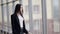 Young brunette woman is looking through the window in the airport