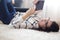 Young brunette woman reading on tablet while lying on carpet