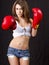 Young brunette woman with red boxing gloves