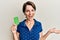 Young brunette woman with short hair holding birth control pills celebrating achievement with happy smile and winner expression