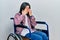 Young brunette woman sitting on wheelchair rubbing eyes for fatigue and headache, sleepy and tired expression