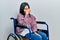 Young brunette woman sitting on wheelchair tired rubbing nose and eyes feeling fatigue and headache