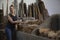 Young brunette woman smiling as she stacks freshly cut firewood in warehouse. Copy space