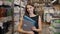 Young brunette woman, student, trainee or employee, smiling while choosing the right book or file from the office in