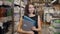 Young brunette woman, student, trainee or employee, smiling while choosing the right book or file from the office in