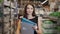 Young brunette woman, student, trainee or employee, smiling while choosing the right book or file from the office in