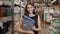 Young brunette woman, student, trainee or employee, smiling while choosing the right book or file from the office in