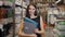 Young brunette woman, student, trainee or employee, smiling while choosing the right book or file from the office in