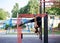 Young brunette woman, wearing black fitness overall, doing stretching exercises, hanging on horizontal bars on sports playground