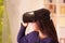 Young brunette woman wearing virtual reality goggles experiencing future technology, interacting and smiling while