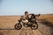 Young brutal man laying on his motorcycle and posing