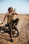 Young brutal man sitting on his motorcycle and drinking water