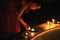 Young buddhist monk lighting candles