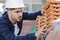 young builder checking roof tiles