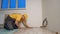 Young builder laying parquet in new apartment.