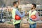 Young builders shaking hands making an agreement on costruction site - Workers reaching a deal and laughing