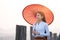 A young Burmese woman is walking with a red umbrella on the longest teak bridge in Asia. U-bein bridge, Mandalay, Myanmar. Space