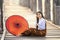 A young Burmese woman wearing traditional clothes with red umbrella at U Bein teak bridge on Taungthaman lake in Mandalay