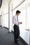 Young Businesman Standing In Corridor Of Modern Office Building