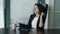 Young business lady sitting behind the desk with tablet, shaking head, being dissapointed and tired. Woman having