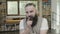 Young business man with beard going through multiple reactions at the office -