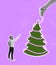 Young business man decorating a creative christmas tree isolated on pink background. Holiday, winter, wishes, New Year