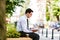 Young Business Man Flipping Through Book While Sitting Outdoor