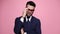 young business man posing on pink background