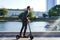 Young business man in a suit riding an electric scooter on a business meeting.