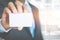 Young business man wear suit holding white business card on modern office