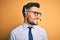 Young business operator man wearing customer service headset from call center looking away to side with smile on face, natural