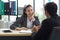 Young business woman in a black suit smiled and laughed happily during the meeting. Morning work atmosphere In a modern office