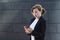 Young business woman in a business suit looks in surprise at the phone. girl, lady receives and reads good news.