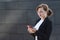 Young business woman in a business suit looks upset and displeased at the phone. girl receives and reads bad news. lady looks