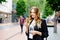 Young business woman eating ice cream. Happy alone woman in in the city on sunny summer day, break for lunch between