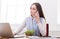 Young business woman eating salad at office