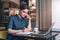 Young business woman in gray dress sitting at table in cafe, talking oncell phone while taking notes in notebook.