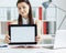 Young business woman holding tablet with copy space for text or picture. Stylish modern office workplace on a background