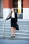 Young business woman leaving a business building carying a bag in her hand