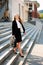 Young business woman leaving a business building carying a bag in her hand