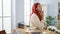 Young business woman, a pensive redhead worker, walks & thinks doubts within her office while multitasking, a serene portrait of