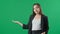 Young business woman presenting product on green background. Portrait of female professional pointing hand to copy space